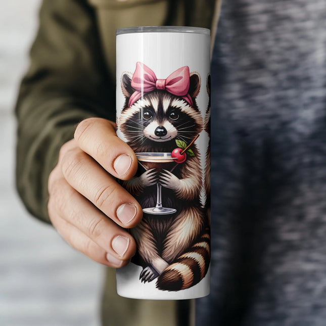 a person holding a coffee mug with a raccoon on it