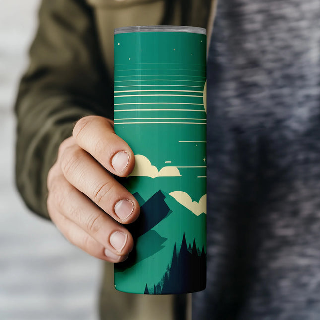 a person holding a cup with a mountain scene on it