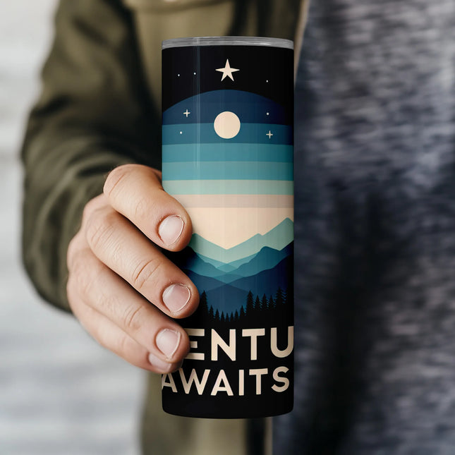 a person holding a travel mug with a mountain scene on it